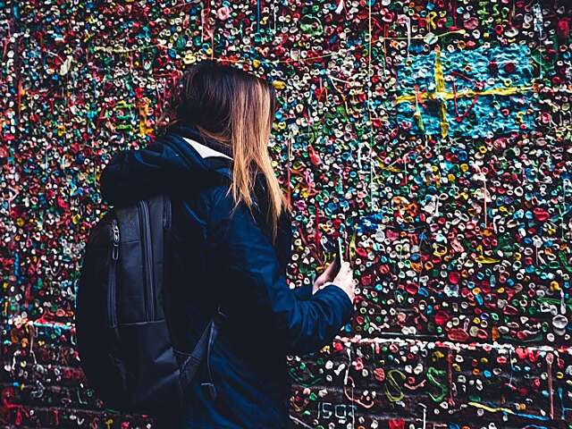 Young woman taking cell phone picture of gum wall 2021 09 03 00 52 36 utc